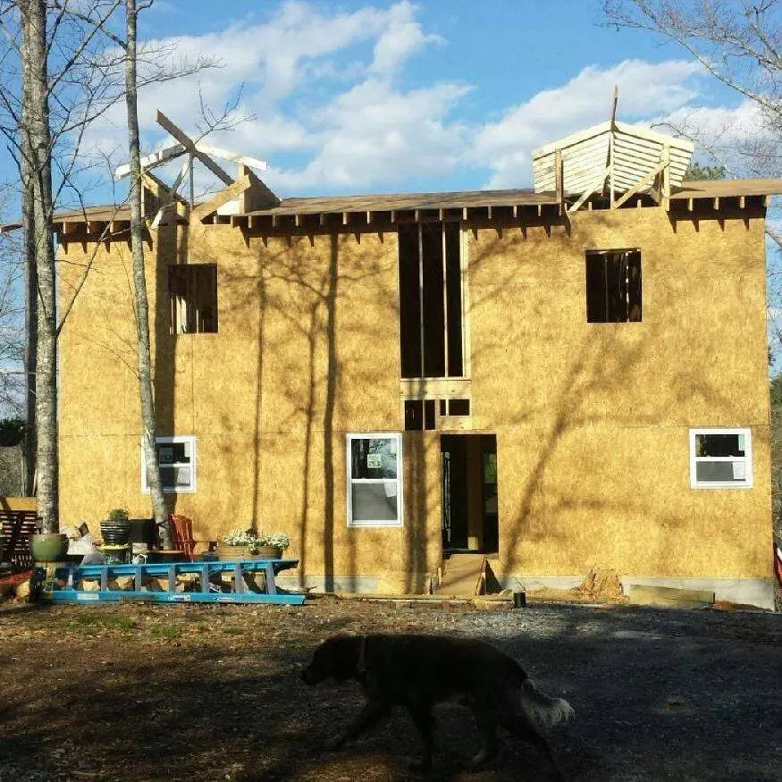 Two-story structure framed and sheathed with window openings cut in