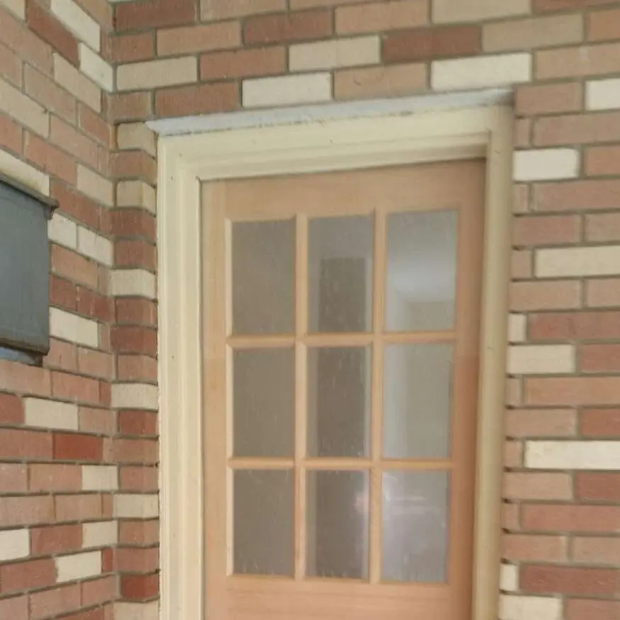 New wood door with glass panes set in a brick wall