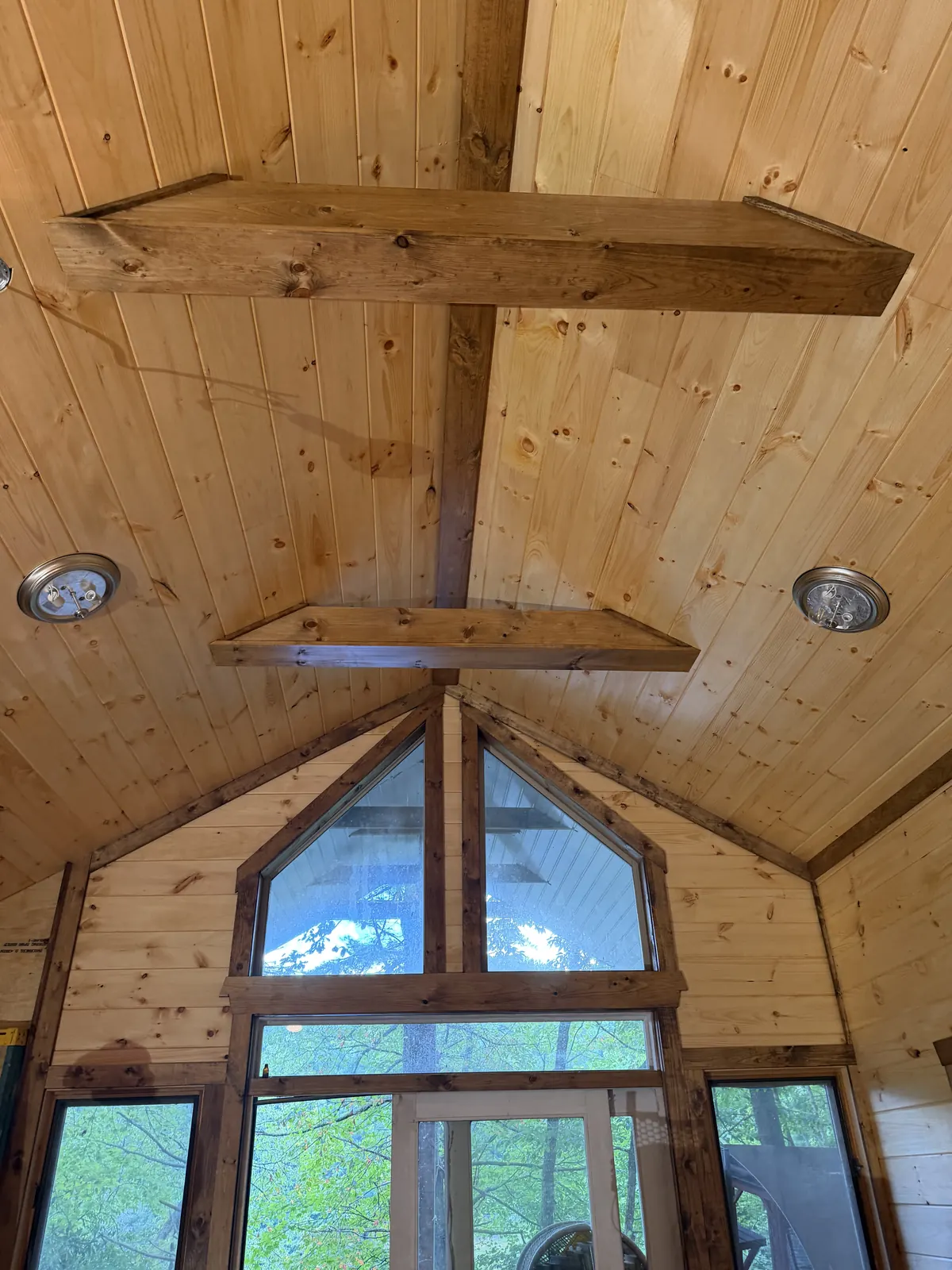Vaulted pine ceiling with timber beams over a wall of gable windows