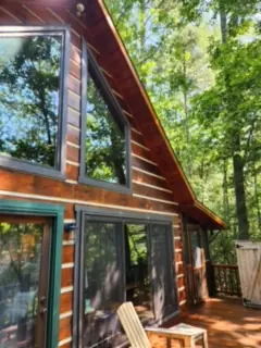 Glass gable wall of a stained log chalet