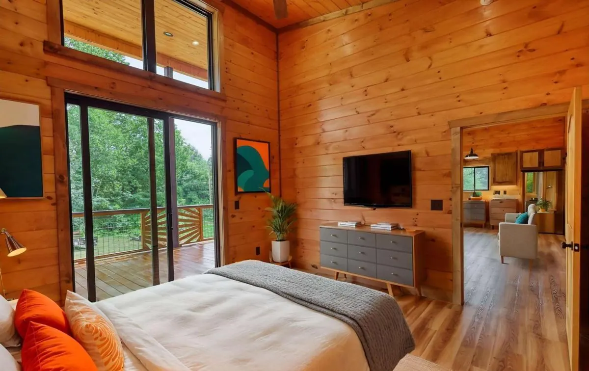Bedroom with a sliding door to the deck, shown virtually staged