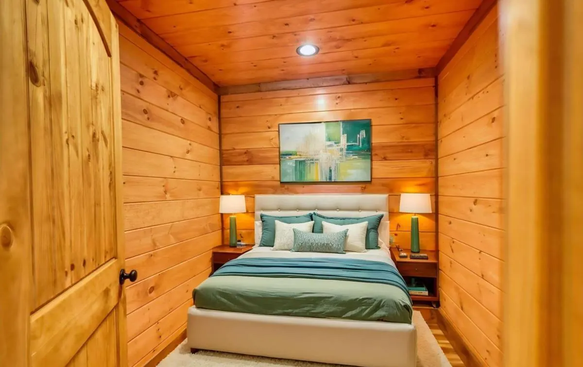 Small bedroom with pine walls, shown virtually staged