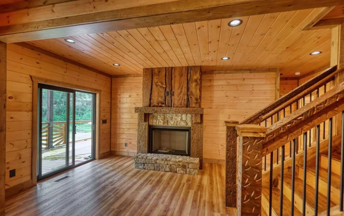 Living room with fireplace, sliding glass door and stair railing