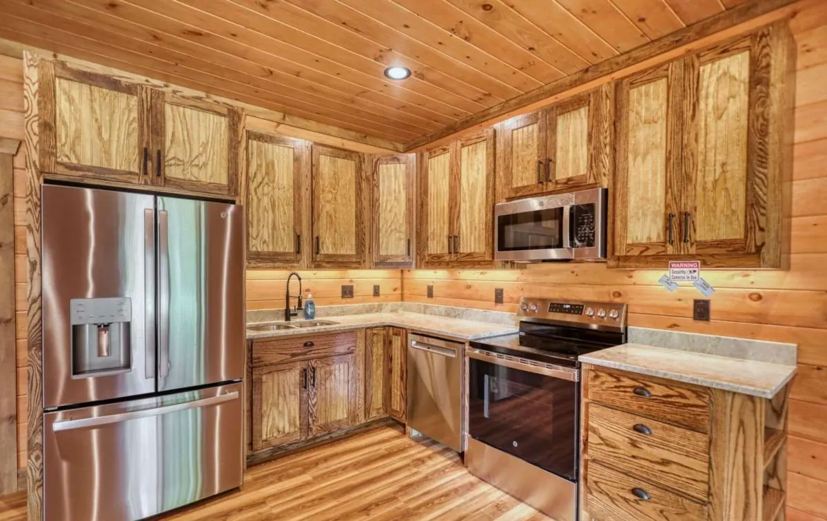 Kitchen with rustic pine cabinets, stainless appliances and under-cabinet lighting