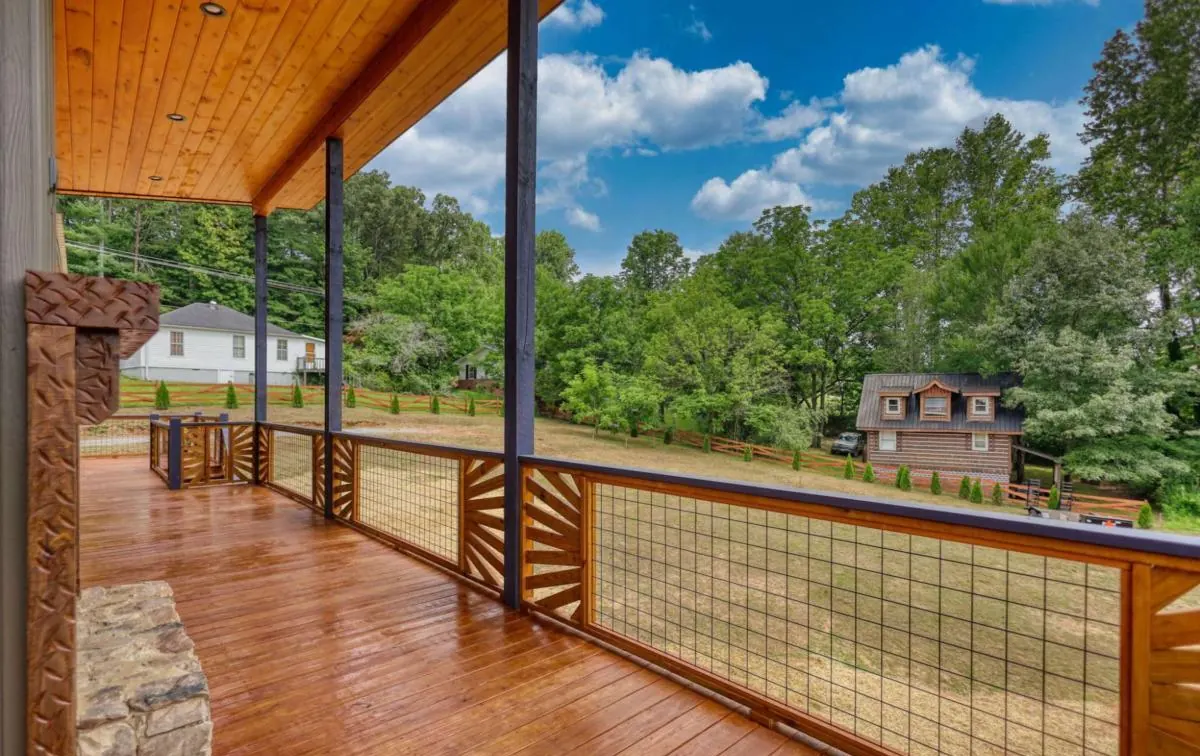 Covered porch with a sunburst-pattern railing and a tongue-and-groove ceiling