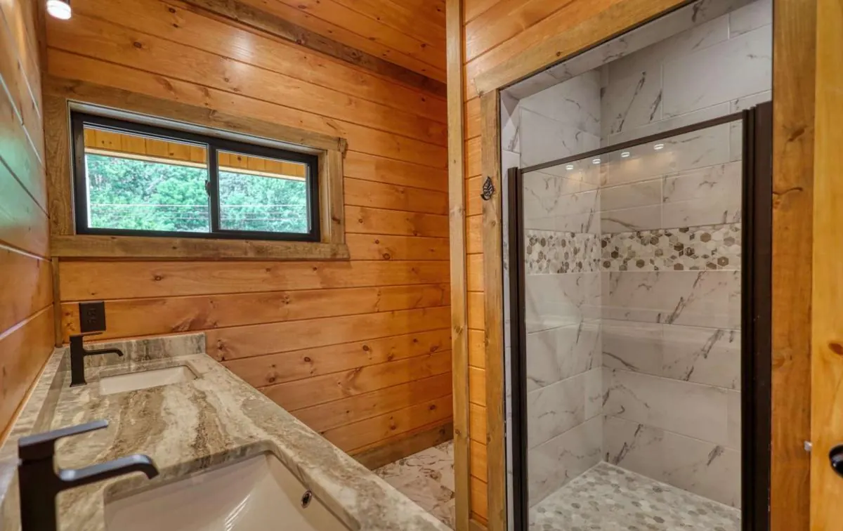 Bathroom with a stone counter and a glass walk-in shower