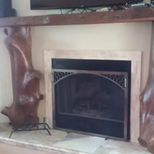 Fireplace surround framed with natural cedar log posts and a timber mantel