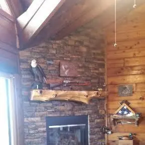 Live-edge wood mantel on a stacked stone fireplace