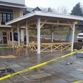 Open pavilion being built over a flagstone patio