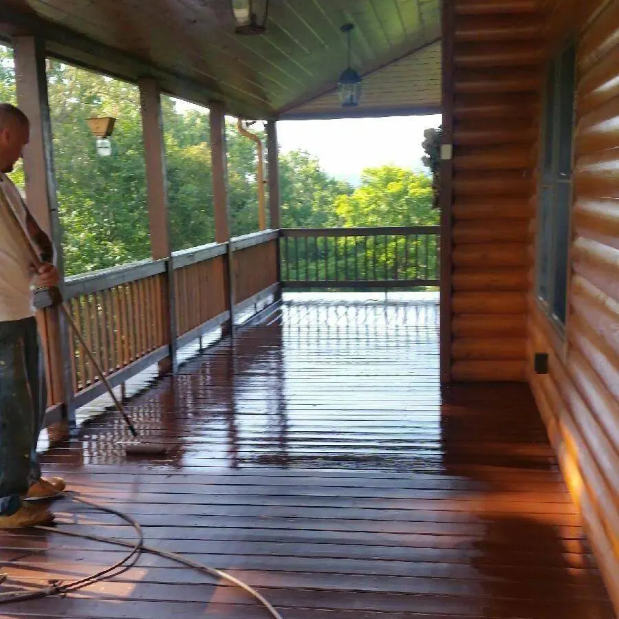 Wraparound porch on a log home with wet stain on the deck boards