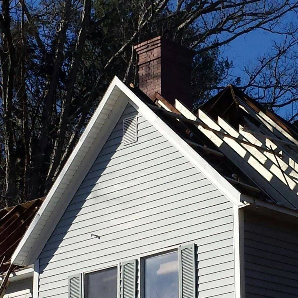 Gable end of a house with the roof stripped to the framing