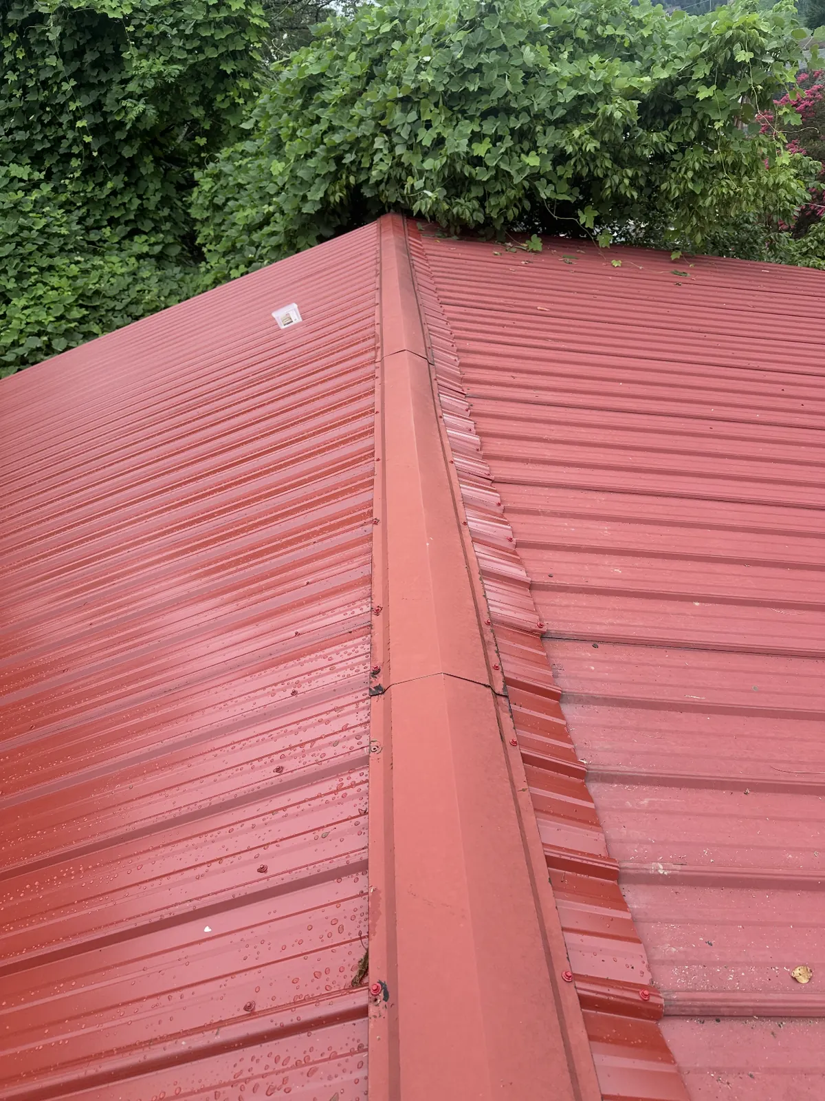 Ridge cap on a newly finished red metal roof
