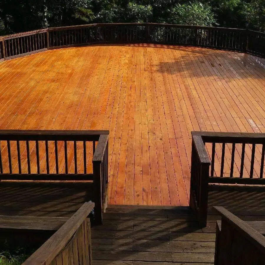 Large curved wood deck with dark railings after refinishing