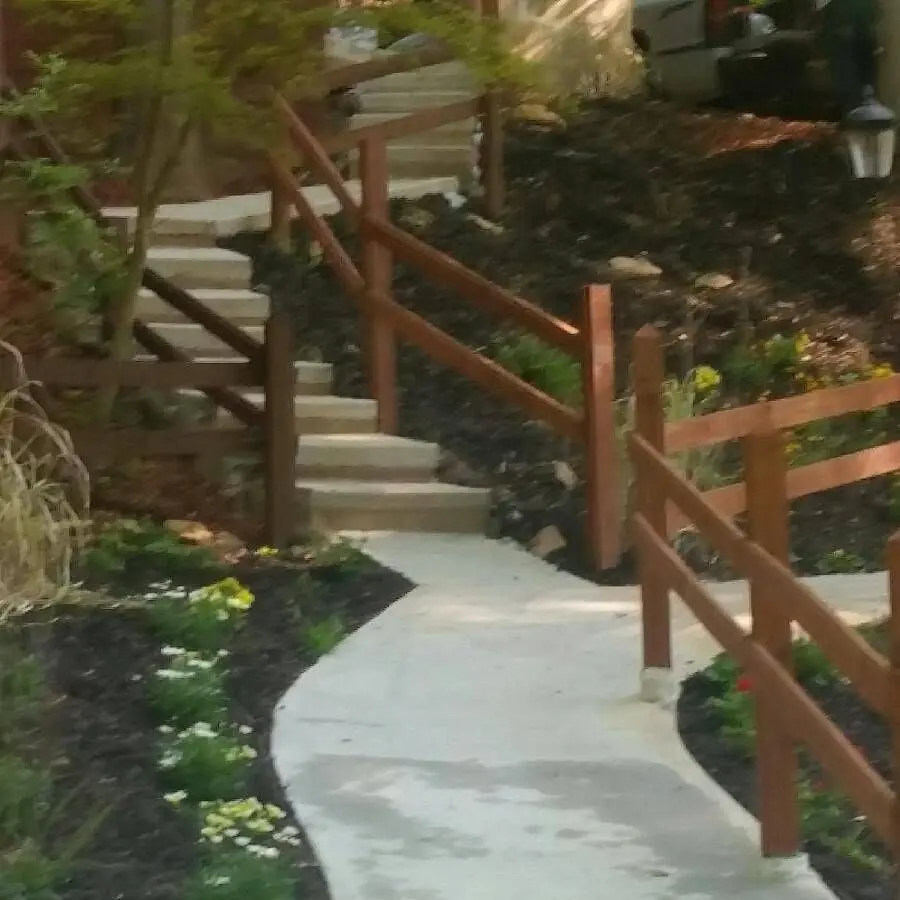 Concrete steps and walkway with wood handrails climbing a hillside